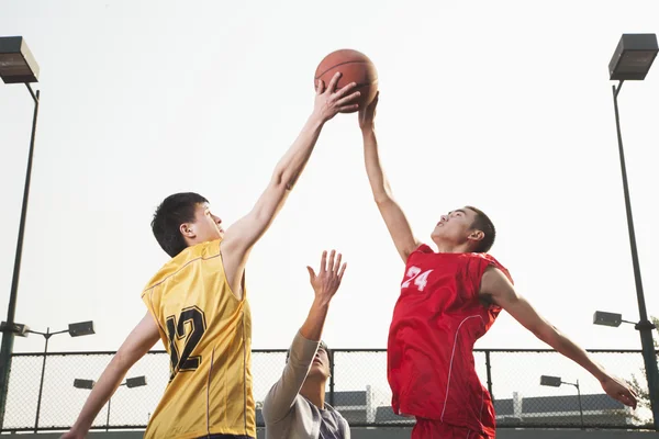 Basketball players fighting for a ball — Stock Photo, Image