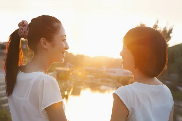 Twee jonge vrouwen op zoek bij zonsondergang — Stockfoto