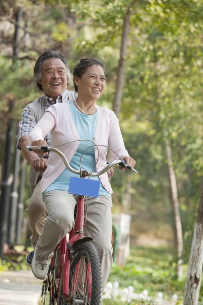 Pareja mayor montando bicicleta en tándem — Foto de Stock