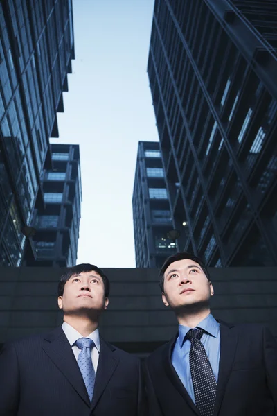 Businessmen standing side by side outdoors — Stock Photo, Image