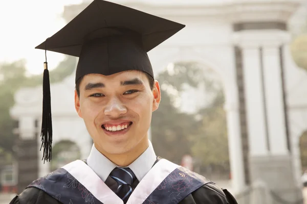 Jonge afgestudeerden in cap en jurk — Stockfoto