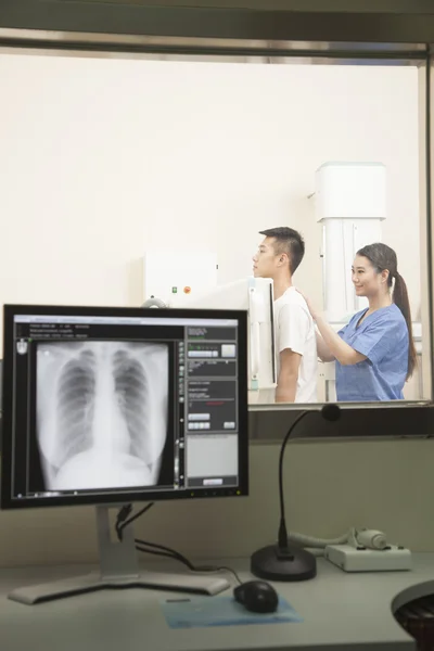 Lékař zkoumá pacienta s x-ray stroj — Stock fotografie