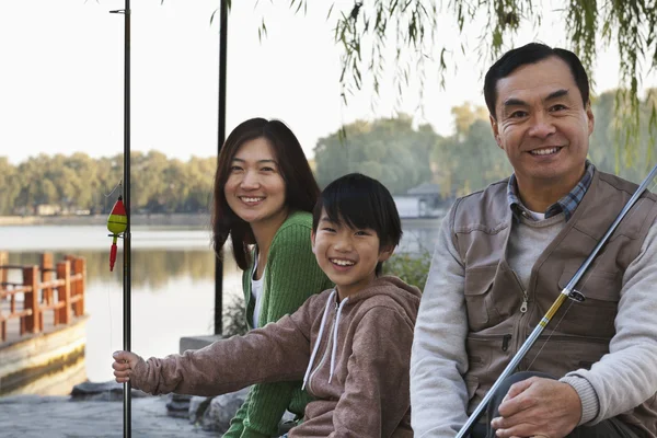 Ritratto di famiglia con attrezzatura da pesca in un lago — Foto Stock