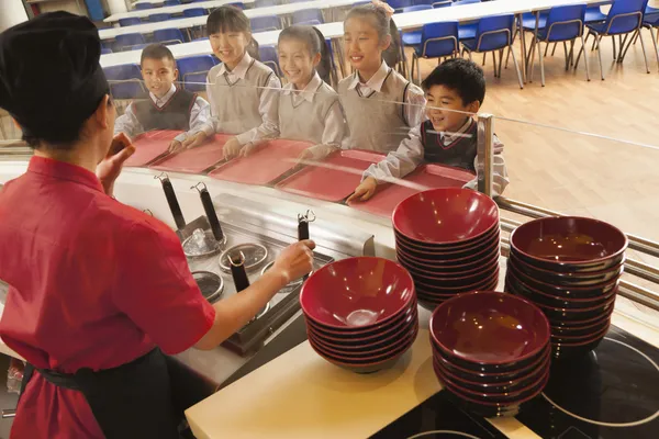 Σχολή Καφετέρια εργαζόμενο σερβίρει noodles σε φοιτητές — Φωτογραφία Αρχείου