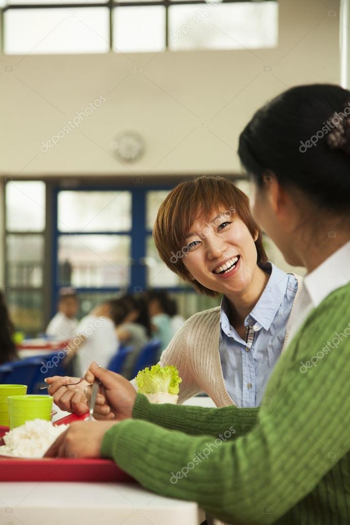 Teachers talking at lunch in school cafeteria ⬇ Stock Photo, Image by