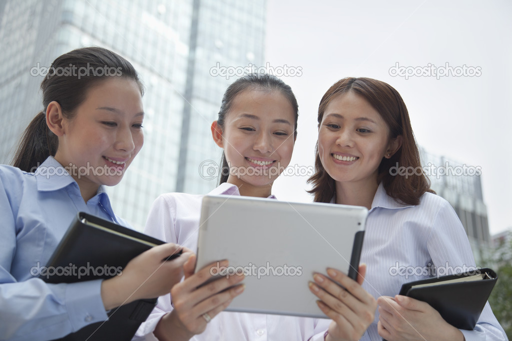 Three young businesswomen discussing outdoors