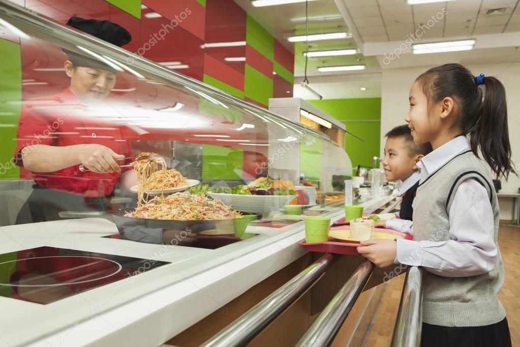 School children standing in line in school cafeteria — Stock Photo