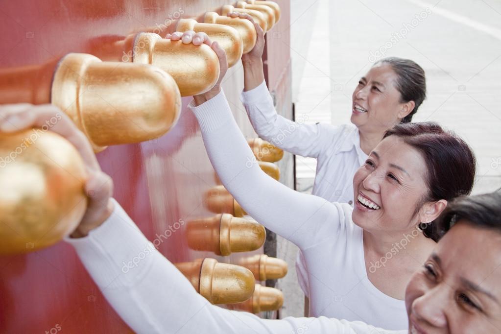 Women standing next to the traditional Chinese door