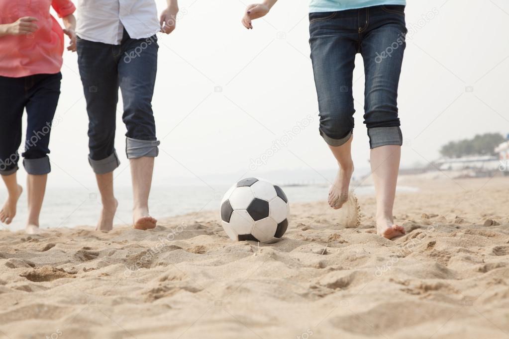 Young Friends Playing Soccer on the Beach