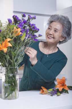 Senior Woman Touching a Bouquet clipart