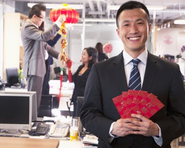 Businessman holding red envelopes clipart