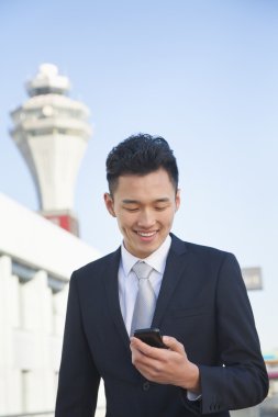Havaalanında cep telefonu mesajı bakarak traveler