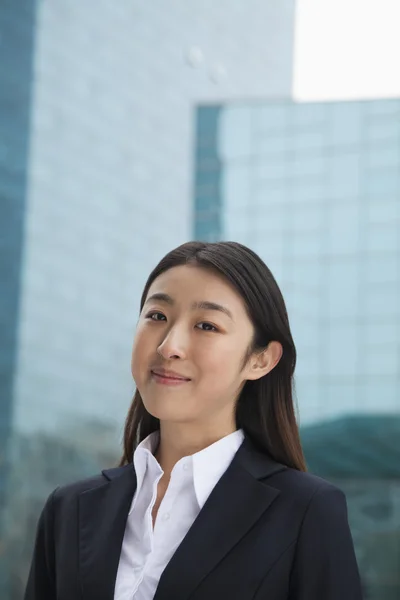 Businesswoman outdoors among skyscrapers — Stock Photo, Image