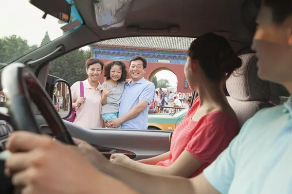 Eltern fahren Auto und verabschieden Sohn und Großeltern — Stockfoto