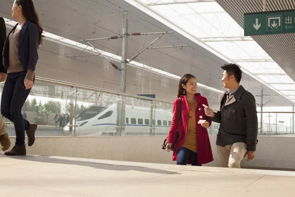 Woman talking to man on railway platform — Stock Photo, Image