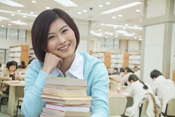 Mulher sorridente na biblioteca — Fotografia de Stock