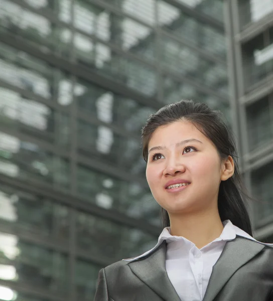 Businesswoman outdoors among skyscrapers — Stock Photo, Image