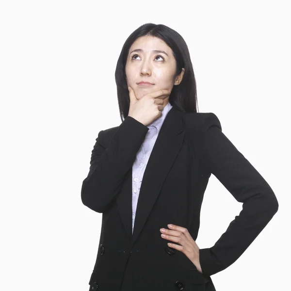 Businesswoman with hand on chin thinking — Stock Photo, Image