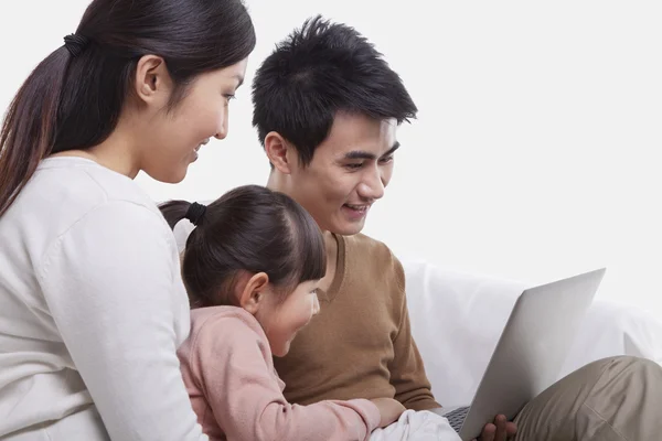 Familia sentada en el sofá mirando el portátil — Foto de Stock