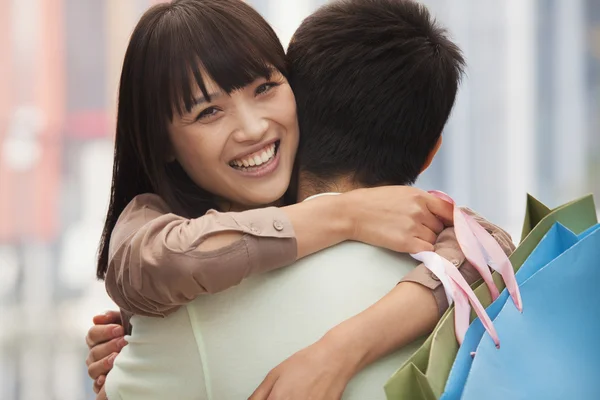 Casal abraçando com sacos de compras — Fotografia de Stock