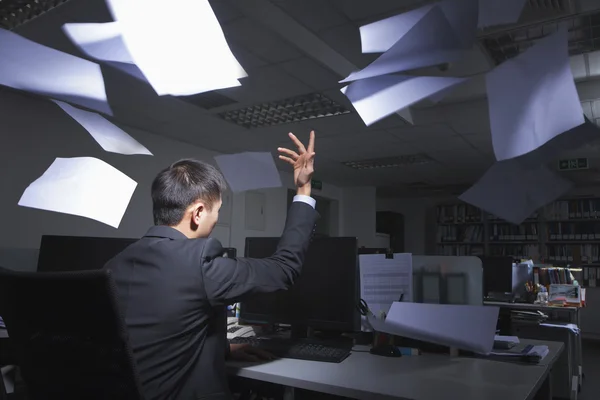 Lavoratore colletto bianco gettando lenzuola bianche in aria in ufficio — Foto Stock