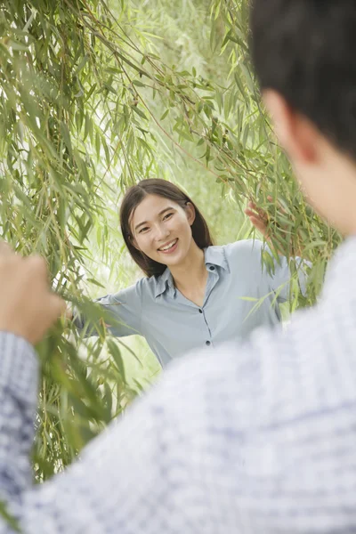 Pareja mirando a través de ramas de sauce — Foto de Stock