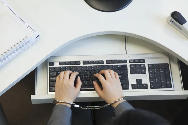 Businesswoman handcuffed to her office chair — Stock Photo, Image