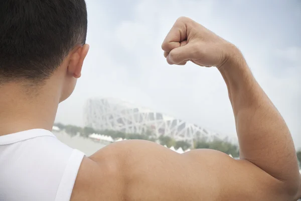 Young man flexing his bicep — Stock Photo, Image