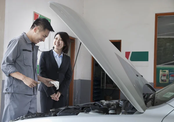 Chiacchierando meccanico e ridendo con il cliente — Foto Stock