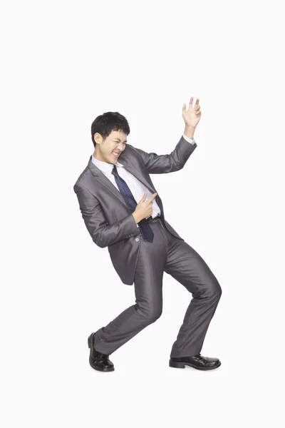 Businessman playing air guitar — Stock Photo, Image