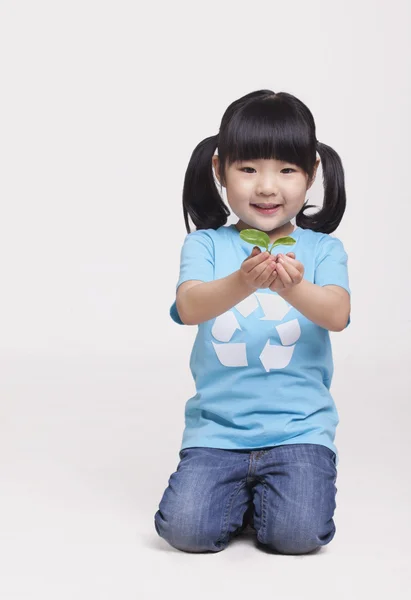 Niña sosteniendo una plántula — Foto de Stock