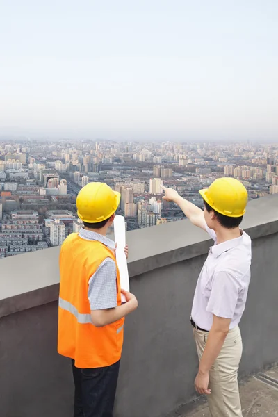 Arquitecto y obrero de la construcción hablando en la azotea —  Fotos de Stock