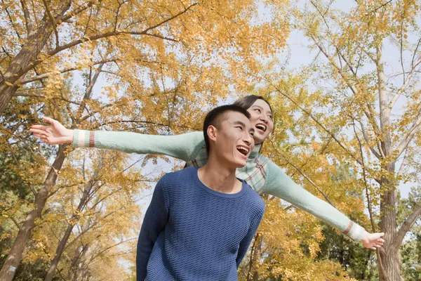 Paar piggyback in park — Stockfoto