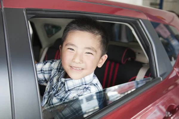 Pojke tittar ut en bil fönstret — Stockfoto