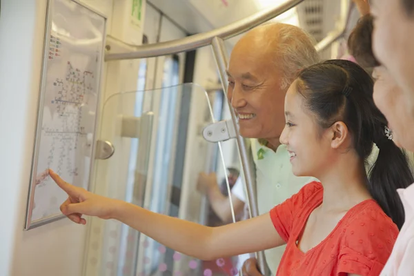Внучка с бабушкой и дедушкой в метро — стоковое фото