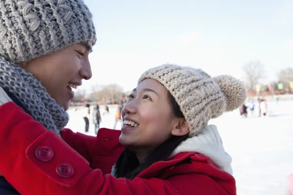 Paar umarmt sich auf Eisbahn — Stockfoto