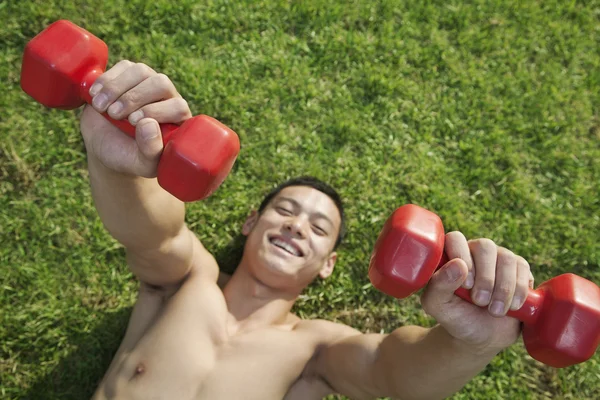 Man Exercising with Dumbbells in Grass — Stock Photo, Image