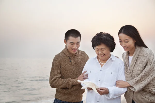 祖父母与孙子女望着海星 — 图库照片