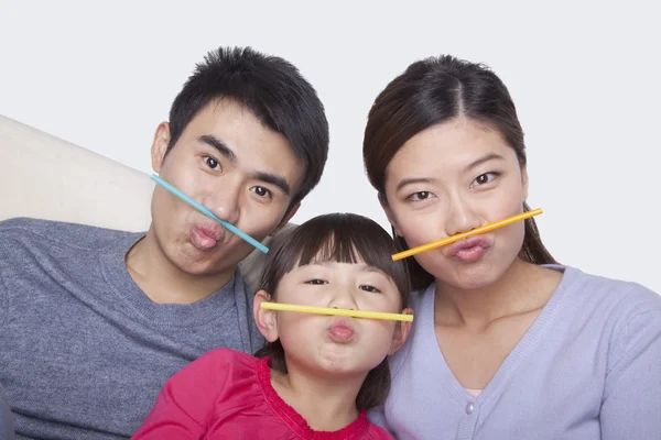 Familjen att göra ett ansikte med dricka sugrör — Stockfoto