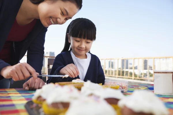 Anya és lánya díszítő cupcakes — Stock Fotó