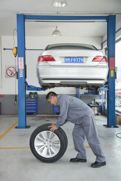 Mechanic Rolling Tire — Stock Photo, Image