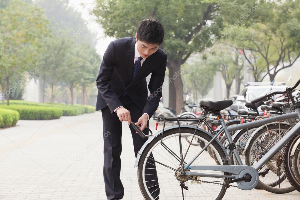 Businessman locking up his bicycle
