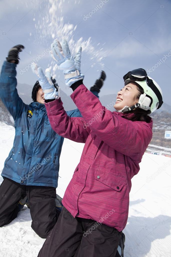 Man and Woman Playing in the Snow in Ski Resort