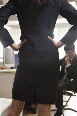 bir iş arkadaşınız karşı karşıya kalça üzerinde elleriyle iş kadını
