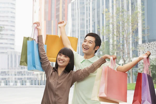 Couple posing with shopping bags — Stock Photo, Image