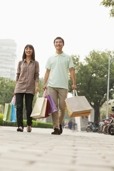 Paar wandelen met shopping tassen — Stockfoto