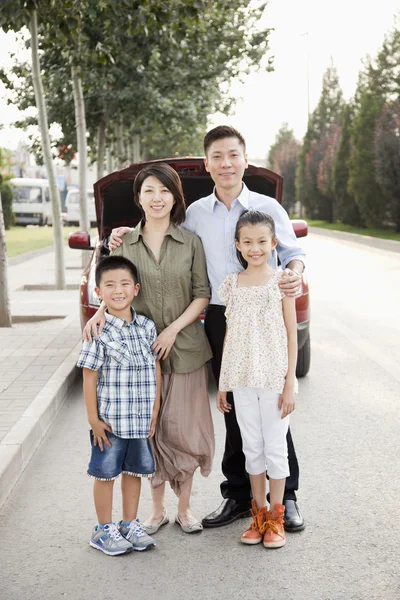 Familie portret voor auto op weg — Stockfoto