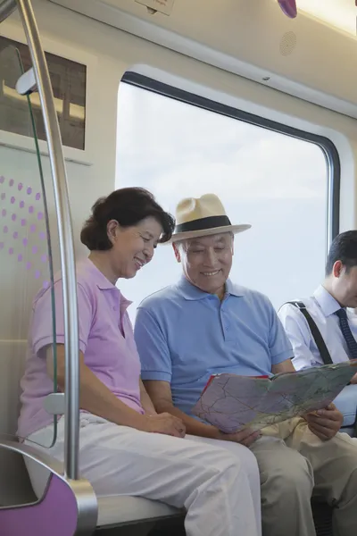 Reifes Paar sitzt in der U-Bahn und schaut auf die Karte — Stockfoto