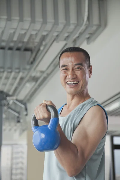 Homme soulevant des poids dans la salle de gym — Photo