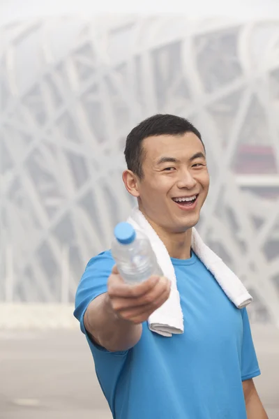 Athletic man in Beijing pointing water bottle — Stock Photo, Image